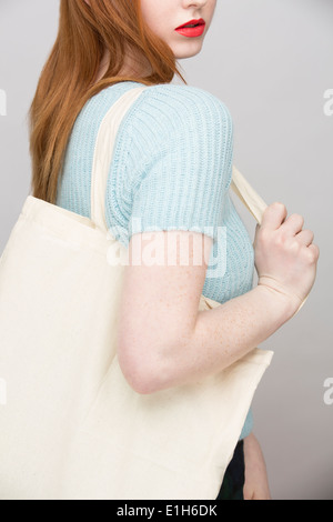 Immagine ritagliata della giovane donna che trasportano shopping bag Foto Stock