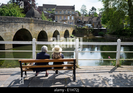 Due signore in appoggio su un sedile accanto al fiume Avon in Bradford on Avon Regno Unito Foto Stock