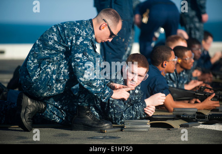 Stati Uniti Navy Chief Gunners Mate Frank Smith, sinistra, incarica uno specialista della logistica di 2a classe di David Elliot, la seconda da sinistra, durante Foto Stock