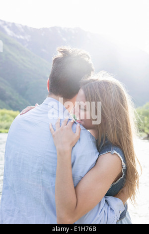 Romantico giovane coppia in riverbank Foto Stock