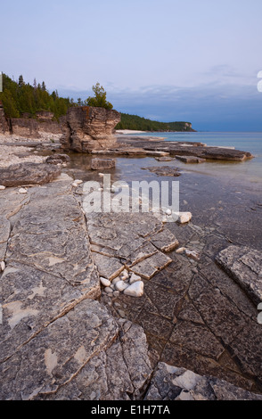 Interessanti formazioni di roccia con una tempesta in arrivo nella distanza. Bruce Peninsula National Park, Ontario, Canada. Foto Stock