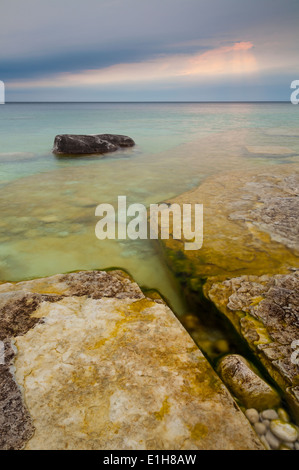 Interessanti formazioni rocciose e acque limpide con interessanti le nuvole in lontananza. Bruce Peninsula NP, Ontario, Canada. Foto Stock