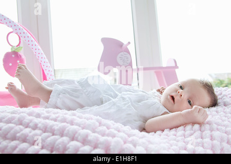 Baby girl giacente a letto Foto Stock