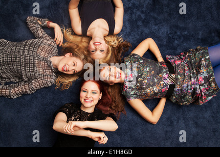 Gruppo di amici sdraiato sul pavimento di moquette Foto Stock