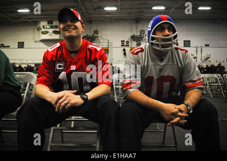 Stati Uniti Navy Aviation Boatswain compagni attrezzature di prima classe e Anthony Rickey, sinistra e Jonathan Dicola guardare il Super Bowl XLVI pr Foto Stock