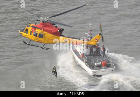 A Forze armate canadesi CH-146 Griffon elicottero assegnato alla Royal Canadian Air Force 424 Squadrone conduce rescue nuotatore hoi Foto Stock