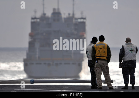 Da sinistra, U.S. Navy Ensign Adam a piedi nudi, Lt. Victor Lange e il tenente La Cmdr. Eric Coop stand sulla prora di assalto anfibio Foto Stock