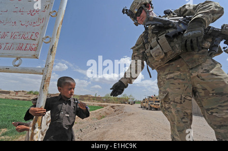 Una coalizione di forze per le operazioni speciali soldato dà una penna per un giovane bambino nel Villaggio Sanawghan, provincia di Herat, Afghanistan, Foto Stock