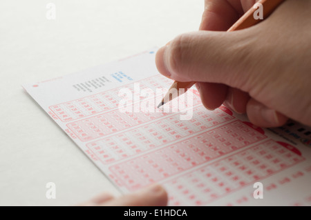Persona numero di marcatura sul biglietto della lotteria con penna Foto Stock