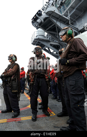 Stati Uniti Navy aviation boatswain compagni manipolazione assegnato al mare in elicottero Combat Squadron (HSC) 6 attendere legare giù aeromobile a t Foto Stock