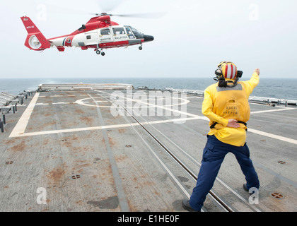 Stati Uniti Coast Guard Ensign Scott Nichols, un segnale di atterraggio ufficiale a bordo della U.S. La guardia costiera della sicurezza nazionale taglierina Waes USCGC Foto Stock