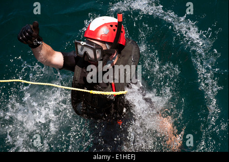 Stati Uniti Navy scafo tecnico di manutenzione Fireman Justin Turner, di una ricerca e salvataggio del nuotatore assegnato al missile distruggere Foto Stock