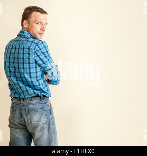 Giovane uomo caucasico in maglietta blu e jeans, ritratto in studio Foto Stock