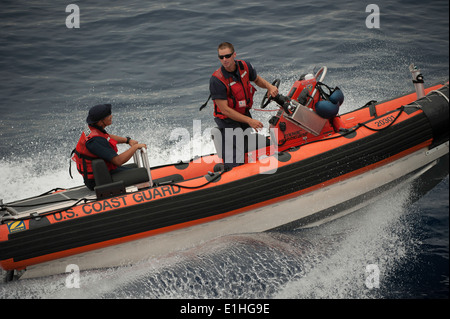 Stati Uniti Costa guardie assegnato a medie endurance taglierina Escanaba USCGC (WPG 77) navigare a fianco della lama in una risposta bo Foto Stock