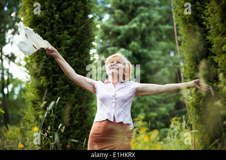 La libertà. Happy Old Lady con Capanna sorridente nel giardino. Stile di vita Foto Stock