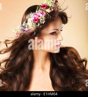 Ritratto di giovane donna Auburn con lunghi capelli fluenti e fiori di campo Foto Stock