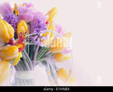 Biglietto di auguri. Bouquet di coloratissimi fiori misti - i tulipani in un vaso. Floristics Foto Stock