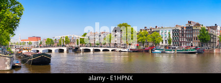 Il Magere Brug ('Skinny ponte") di Amsterdam lungo il fiume Amstel su una bella giornata di sole Foto Stock