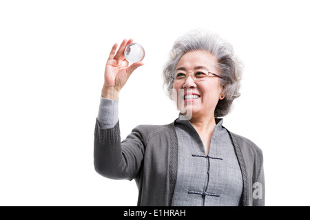 Senior donna con sfera di cristallo Foto Stock