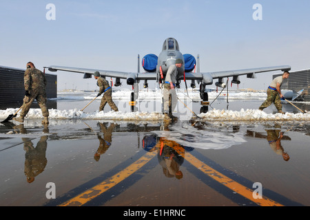 Stati Uniti Avieri assegnato alla 455th Expeditionary Manutenzione aeromobili squadrone chiaro neve attorno ad un A-10 Thunderbolt II a Bagra Foto Stock