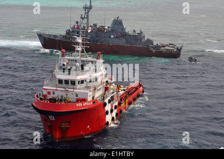 Il rimorchiatore malese VOS Apollo, anteriore, si prepara per le operazioni di defueling vicino a terra il mio contromisure nave USS Guar Foto Stock