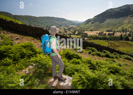 30-35 donna a spasso nel distretto del lago, guardando lungo Langdale Foto Stock