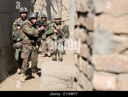 Esercito Nazionale Afghano commandos con la 6. Operazioni Speciali Kandak patrol un vicolo nel distretto di Tagab, provincia di Kapisa, Afgha Foto Stock