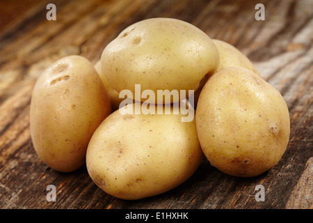 Primo piano di un mucchio di nuove patate su un rustico di legno Foto Stock