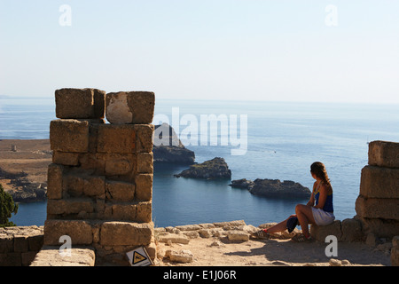 La gente ad esplorare l'acropoli di Lindos e tenuto nelle viste della costa greca, Lindos, Rodi, Rodi, Grecia Foto Stock