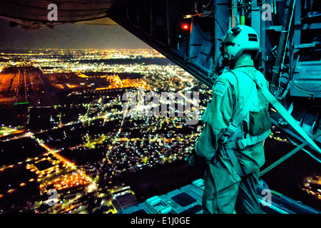 Stati Uniti Air Force Staff Sgt. Nickolas Alarcon, un loadmaster assegnato alla XXXVI Airlift Squadron, osserva una zona di caduta dal r Foto Stock