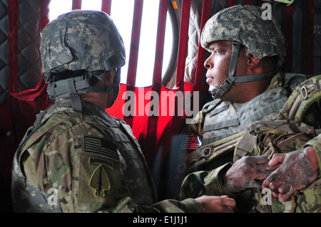 Ritirato U.S. Army Sgt. 1. Classe Jose Mendez e Sgt. Omar Avila guardare al di fuori di un CH-47 elicottero Chinook durante il funzionamento corretto Foto Stock