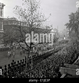 Anni Cinquanta foto storiche che mostra e grandi folle si radunarono come soldati marzo verso il Cenotafio War Memorial, Whitehall, Londra. Foto Stock