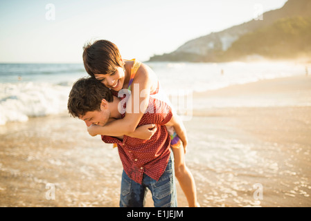 Coppia giovane godendo del tramonto, la spiaggia di Ipanema, Rio, Brasile Foto Stock