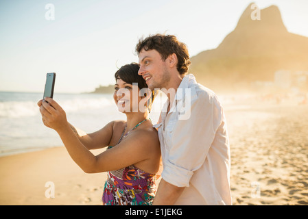 Coppia giovane self-fotografare, la spiaggia di Ipanema, Rio, Brasile Foto Stock