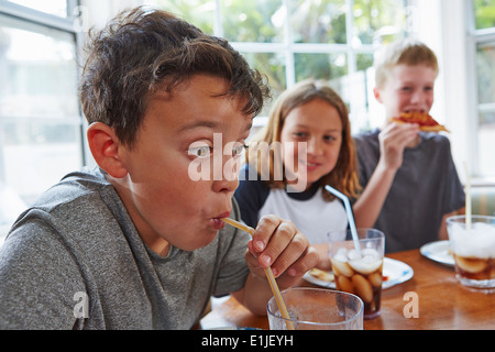 Ragazzo beve bibita attraverso la paglia Foto Stock