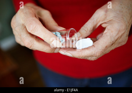 Close up di 82 anno vecchio senior di donna con mano pillola bottiglia Foto Stock