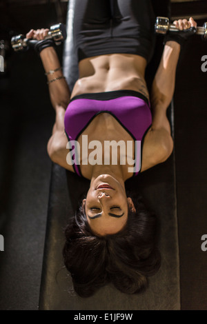 Metà donna adulta utilizzando pesi per addominali esercizio Foto Stock