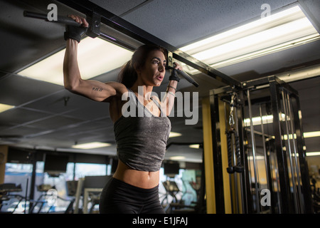 Metà donna adulta facendo esercizio pettorali in palestra Foto Stock