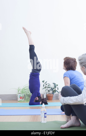 Donna facendo headstand Foto Stock