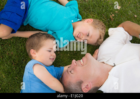 Padre e figli giocare sull'erba Foto Stock