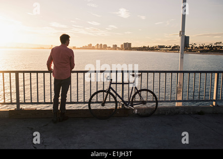 Giovane uomo guardando dal molo, Long Beach, California, Stati Uniti d'America Foto Stock