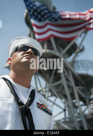 Un U.S. Sailor mans le rotaie a bordo del dock anfibio sbarco nave USS Pearl Harbor (LSD 52) Maggio 25, 2013, come la nave lascia Foto Stock