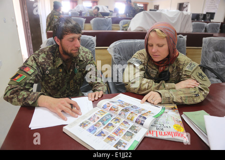 Stati Uniti Esercito Capt. Tammy Sloulin, con la 81st gli affari civili battaglione, assiste l esercito nazionale afgano (ANA) Lt. Ah Manir Nirgar, un Foto Stock