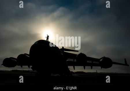 Stati Uniti Air Force Tech. Sgt. Andrew Gravett è un capo equipaggio con il 437th Manutenzione aeromobili squadrone, passeggiate lungo la parte superiore di una C Foto Stock