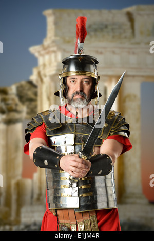 Ritratto del centurione romano la spada con gli antichi edifici in background Foto Stock