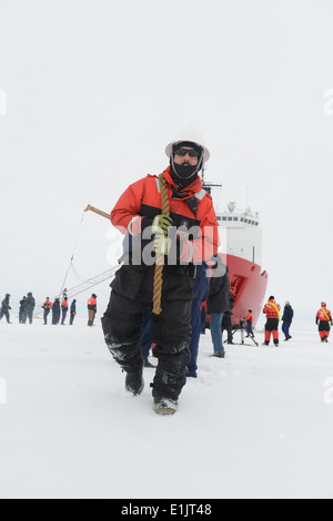 Stati Uniti Coast Guard Chief Petty Officer Troy Shrum, con il guardacoste Healy coperta, tira l'estremità di una linea di whi Foto Stock