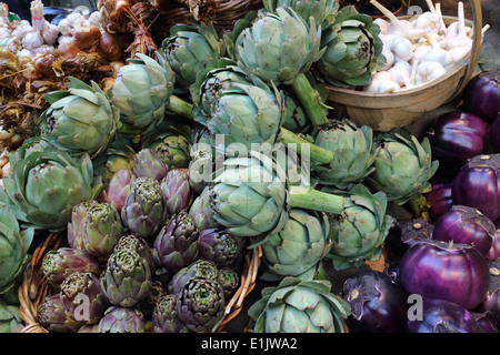 Produzione biologica carciofo, viola melanzane e aglio ortaggi in stallo del mercato Foto Stock