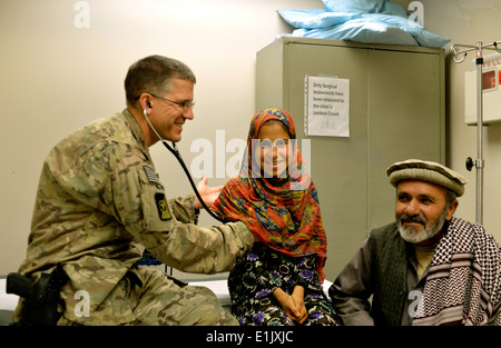 Stati Uniti Air Force Lt. Col. David Jones, a sinistra un pediatra con il 455th Expeditionary Medical Group, esamina un bambino afgano Foto Stock