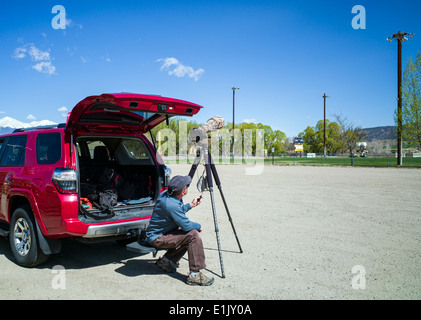 Fotografo H. Mark Weidman lavora con un grande teleobiettivo e treppiede per catturare un annidamento Osprey Foto Stock