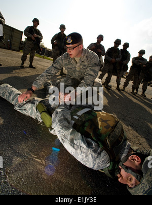 Stati Uniti Air Force Airman 1. Classe Zane Muller, in ginocchio un istruttore con l'ottava delle forze di sicurezza Squadron, cerca di simulare Foto Stock